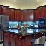 Awesome A small eat-in kitchen with rich cherry wood cabinets and stainless steel kitchen designs with islands for small kitchens
