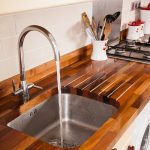 Beautiful Walnut worktops with an undermounted sink cut-out, drainage grooves and a  tap wooden kitchen work tops