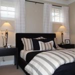 Cozy Basement Bedroom - light beige walls, dark furniture, striped bedding that  pulls window treatments for small bedroom windows