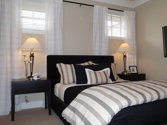 Cozy Basement Bedroom - light beige walls, dark furniture, striped bedding that  pulls window treatments for small bedroom windows
