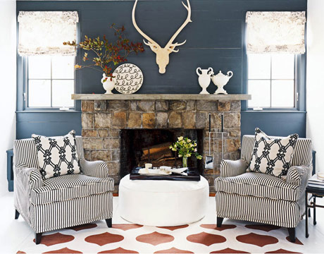 Stunning fireplace with matching chairs and a painted floor and a white ottoman with living room accessories