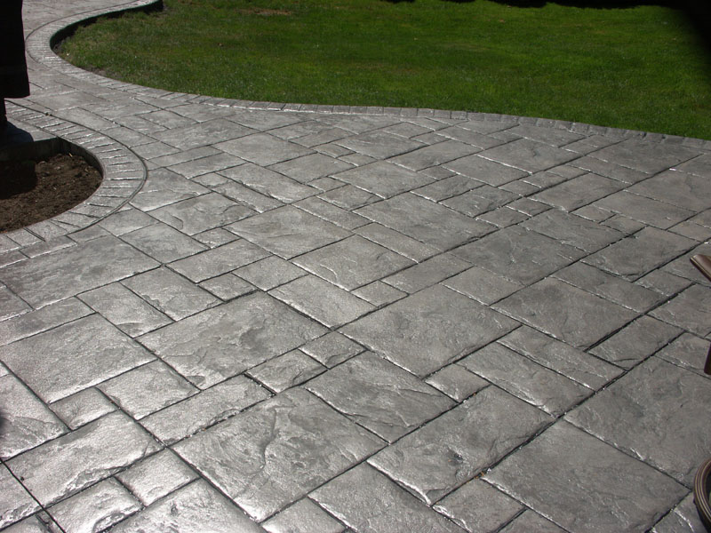grey stamped concrete walkway in a backyard on a sunny day EDBJHTL