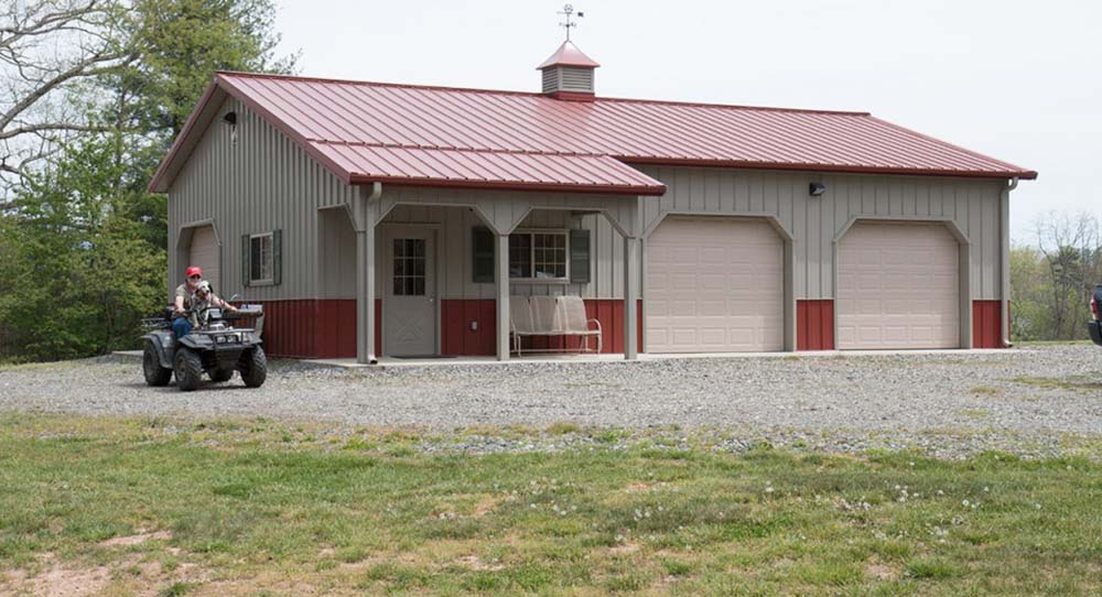 Wide view of the garage showcasing the 3 car doors and the porch entrance  to the enclosed space