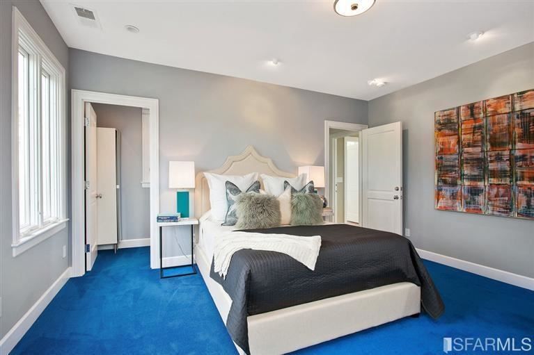 Bedroom with gray whiles and bright blue carpet