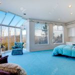 Great design for bedroom with glass wall. Blue carpet floor well matched  with light blue