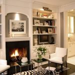 Gorgeous built-in bookshelves surrounding fireplace with sconce lighting.