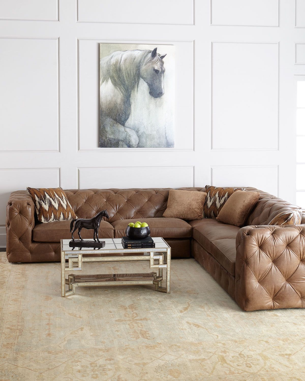 tufted leather sectional with square arms. traditional paneling in neutral  room.