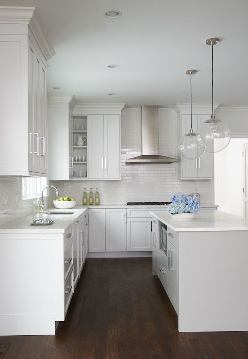 Beautiful kitchen features a pair of clear glass globe pendants