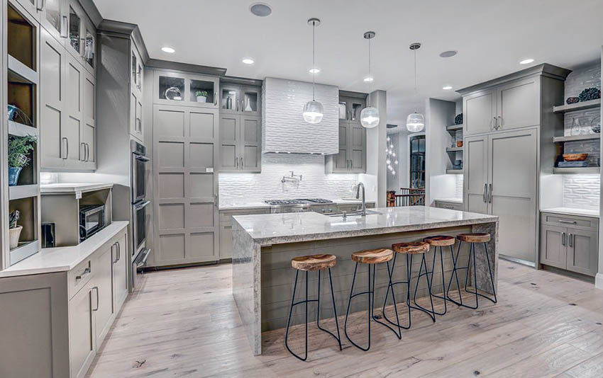 Contemporary kitchen with light gray cabinets, light wood floors and white  textured backsplash