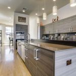 Contemporary kitchen with laminated cabinets and two level breakfast bar  and light wood floors