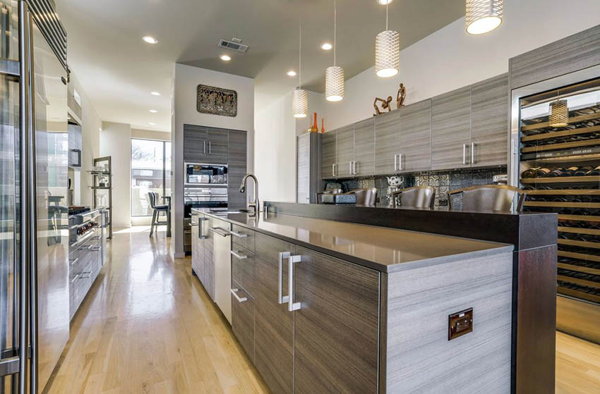 Contemporary kitchen with laminated cabinets and two level breakfast bar  and light wood floors