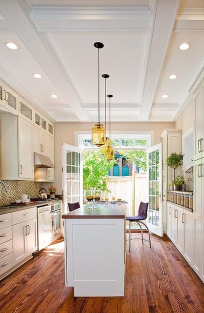 Incredible galley kitchen design with a long island! The wood grain runs  the length of the room making it feel even larger!