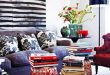 Living room with oversized stripe art and garden stools with art books.