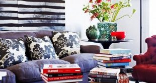 Living room with oversized stripe art and garden stools with art books.