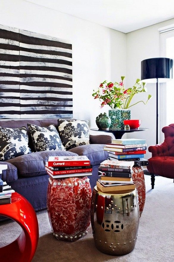 Living room with oversized stripe art and garden stools with art books.