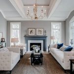 Beautiful living room with white furniture gray paint fireplace and  chandelier