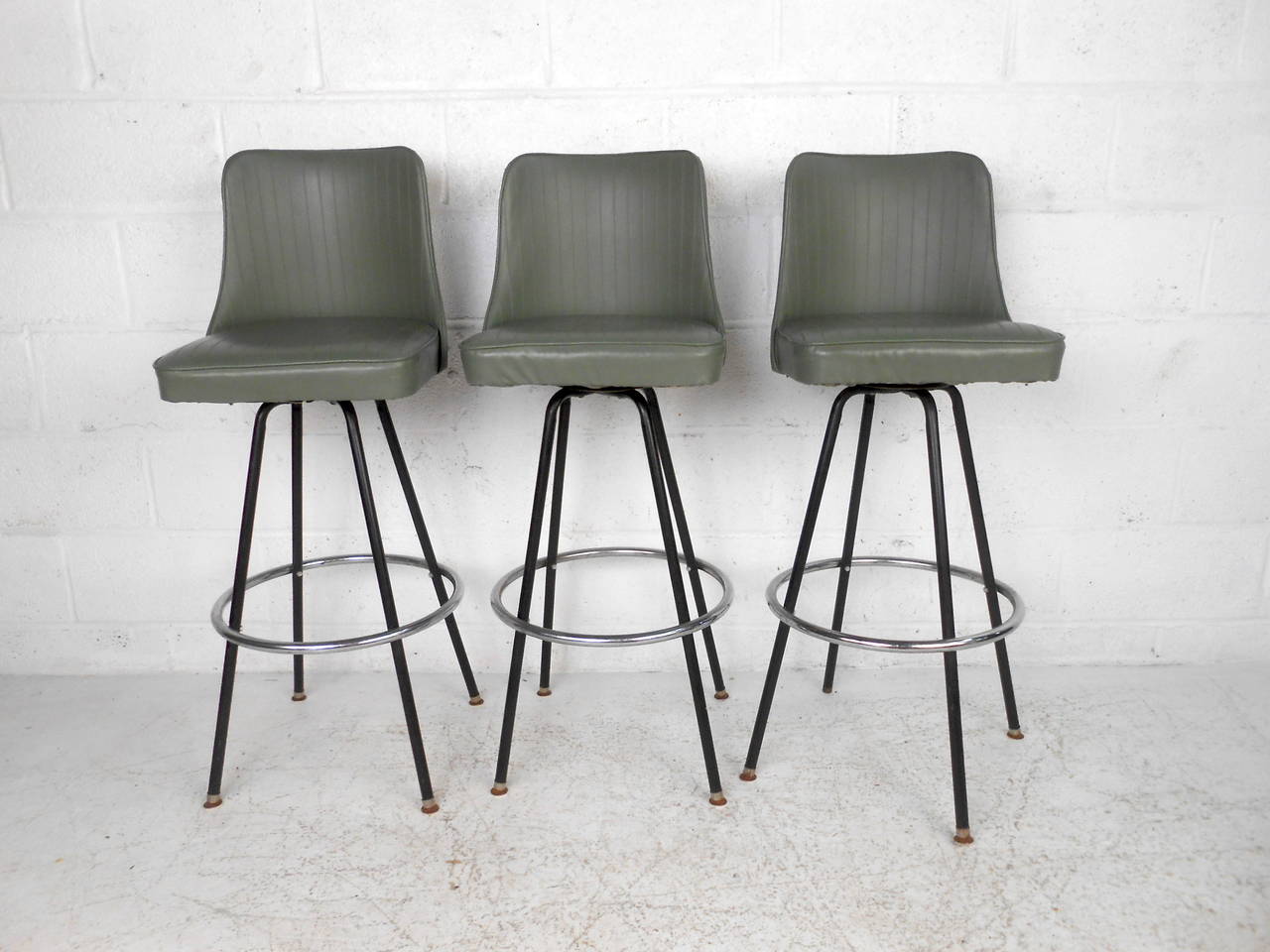 This set of three mid century bar stools by Atlas Specialty Manufacturing  feature a green vinyl