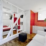 Surprisingly Small Apartment in Paris with a Charming Red and White Interior  Shop this look: ottoman, couch, comforter.