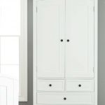 Furniture. white wooden Wardrobe with doors and four drawers also legs on  the floor.