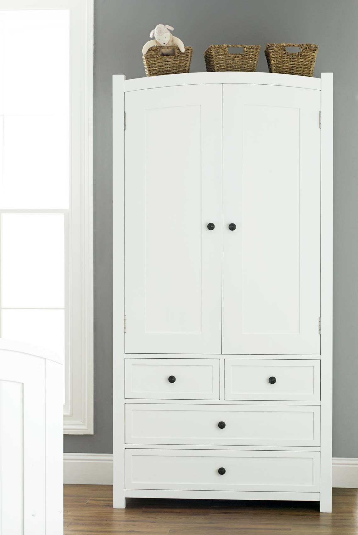 Furniture. white wooden Wardrobe with doors and four drawers also legs on  the floor.